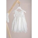 Βαπτιστικό φόρεμα Piccolino Elisa Ivory. Φόρεμα με ιδιάιτερο ύφασμα με σχέδιο στο μπούστο, δαντέλα ζωνάκι στη μέση και ασσύμετρη τούλινη φούστα . Στο φόρεμα ξεχωρίζει η εντυπώσιακή πλάτη όπου ξέκινώντας από τους ώμους αυτή η εντυπωσιακή δαντέλα καταλήγει εώς πίσω χαμηλά στην μέση .Το ντεκόρ του φορέματος αποτελείται από χειροποίητο λουλούδι με μαραμπού και στρας swarovski. Το φόρεμα συνοδέυεται απο κορδέλα με ντεκόρ όμοιο με το φόρεμα